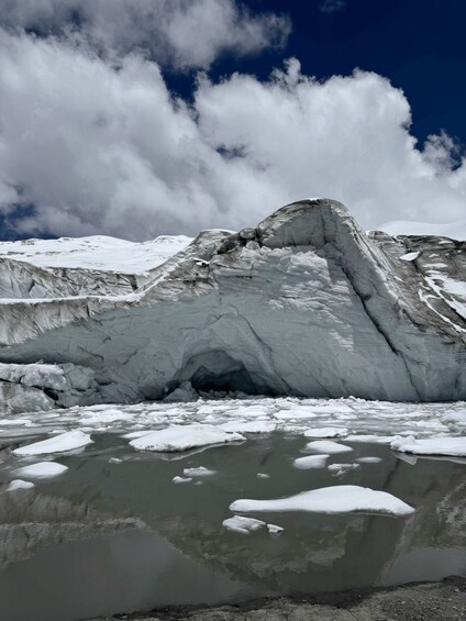 A glacier with a crevasse and a reflective water surface. 2