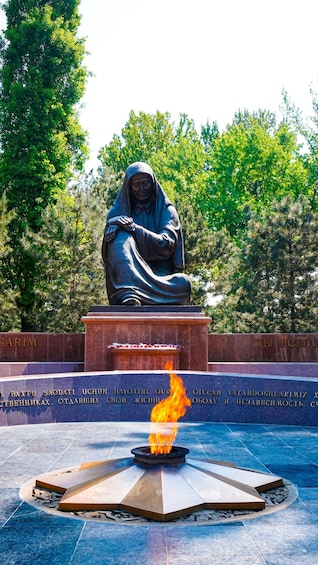 A statue of a robed figure with a fire burning in front of it. 2