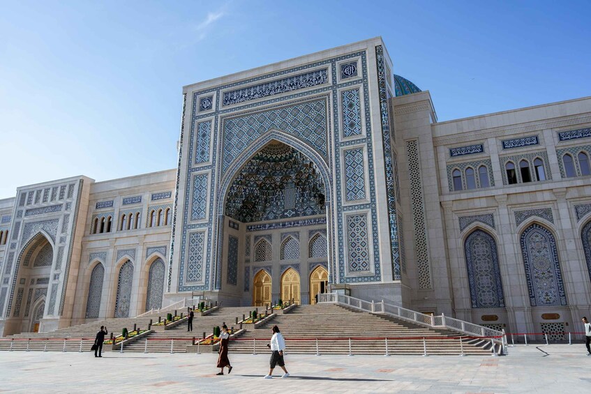 A grand building with intricate blue and white tile work, large arched entrances, and a prominent dome. 3