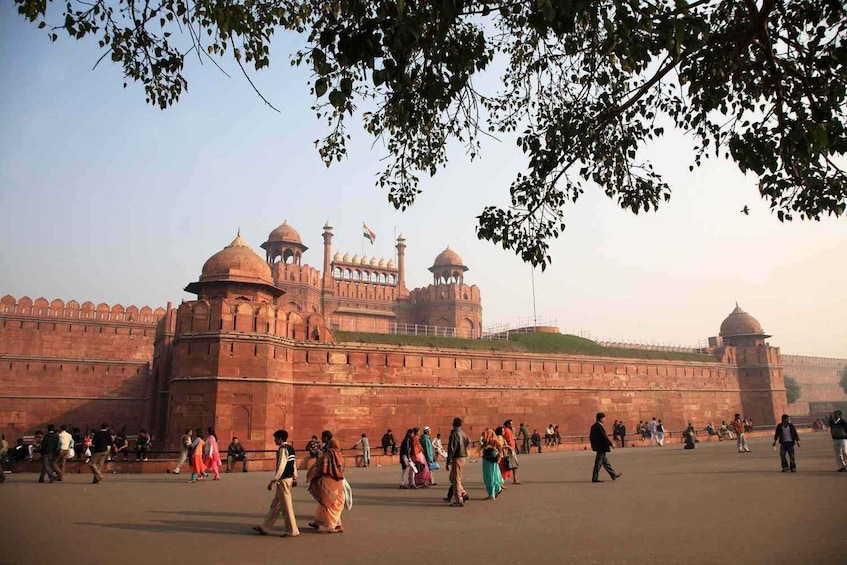 A large historic fort with multiple domes and a prominent gate, surrounded by a crowd of people. 3