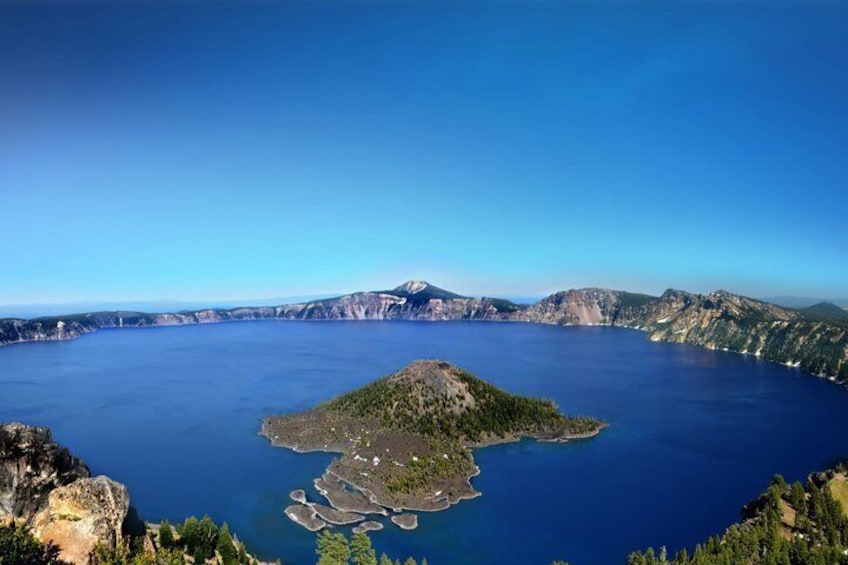 A large body of water surrounded by mountains and a small island with buildings. 1