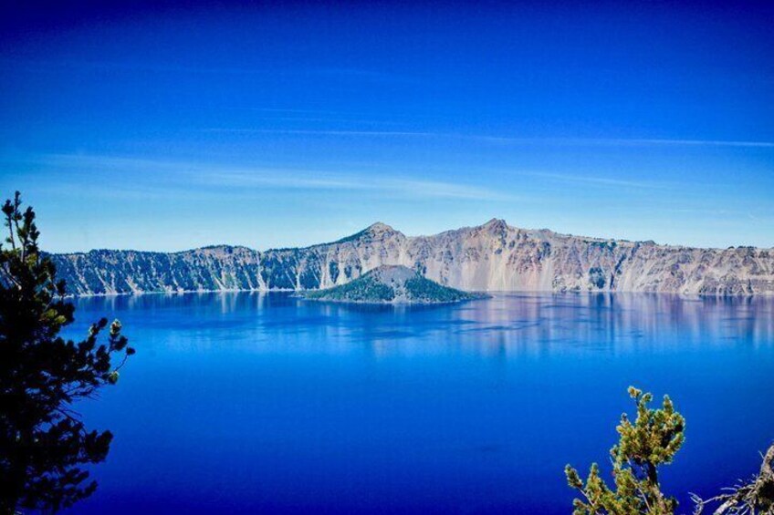 A calm lake with a mountain range in the background and a clear blue sky. 5