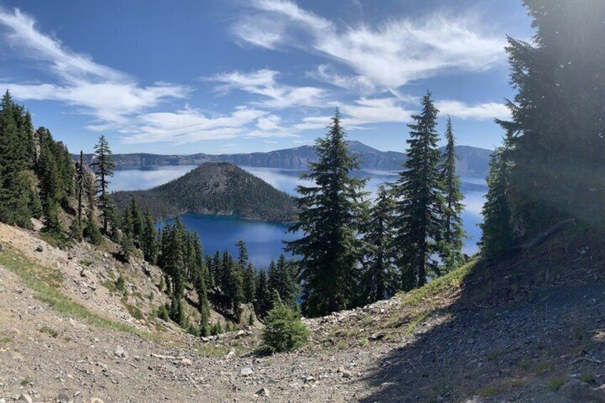 A mountainous landscape with a lake, dense coniferous forest, and a clear sky. 2