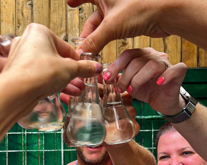 A group of people holding glass bottles, possibly in a social or celebratory setting. 2