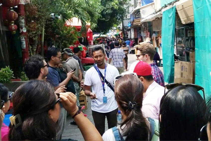 A crowded street market with people shopping and interacting. 1