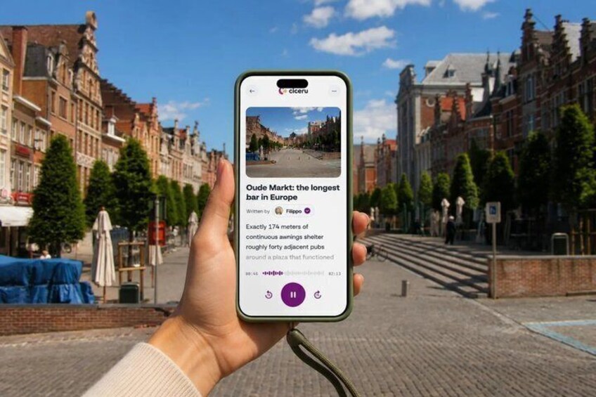 A hand holding a smartphone displaying a news article about Oude Markt, a historic European market area. 1