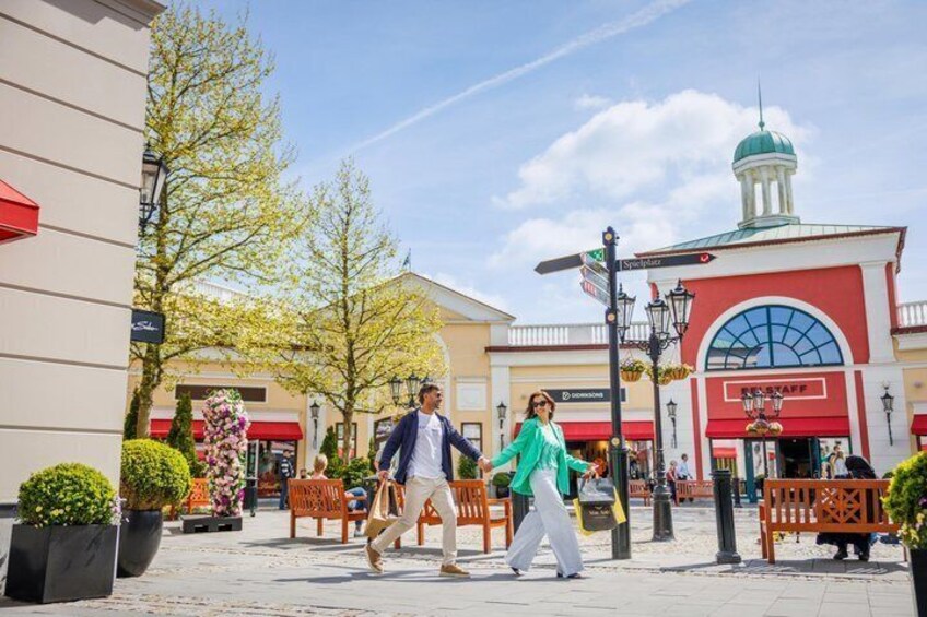 A pedestrian area with benches, a building with a dome, and a street lamp. 1