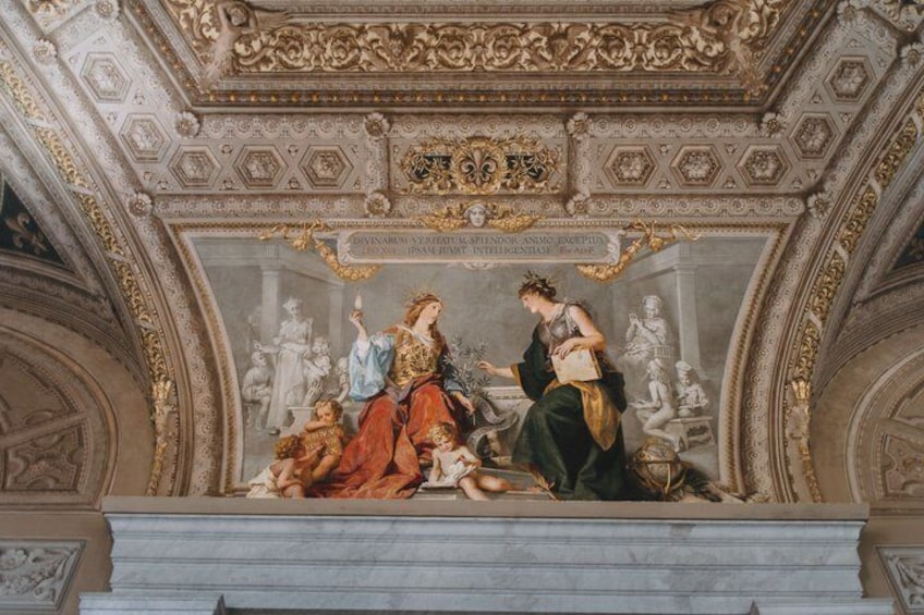 A classical ceiling with intricate carvings and a central fresco. 5