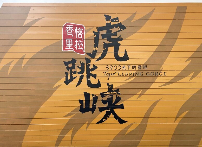A wall with Chinese characters and the name 'Tiger Leaping Gorge' in English. 3