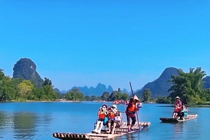 People on paddle boats on a river with mountains in the background. 4
