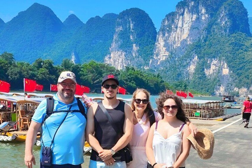A group of people on a boat with a mountainous landscape in the background. 2