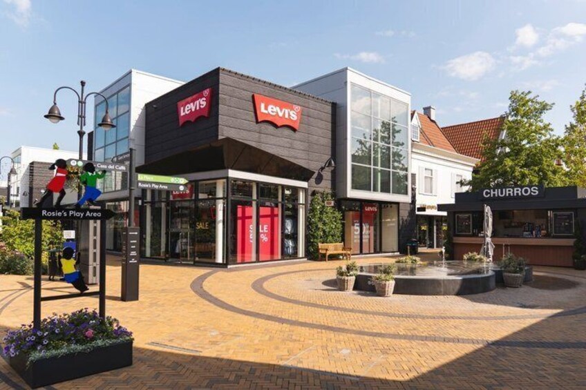 A shopping area with a Levi's store, a churros shop, and a fountain. 3