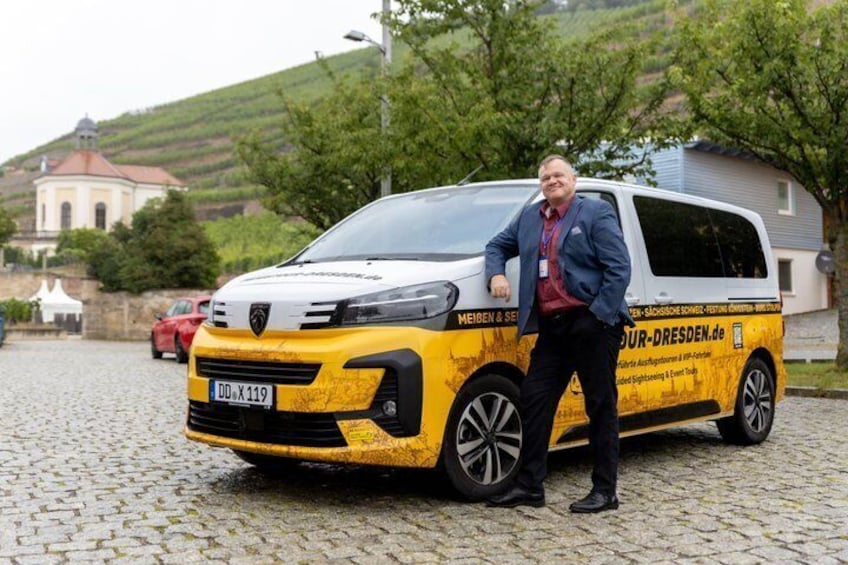 A man standing next to a yellow and white van with 'MEIBEN & SEITZ' branding. 2