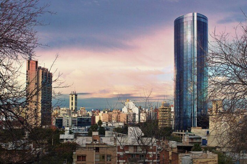 A cityscape with modern high-rise buildings, a mix of residential and commercial structures, and a clear sky. 2