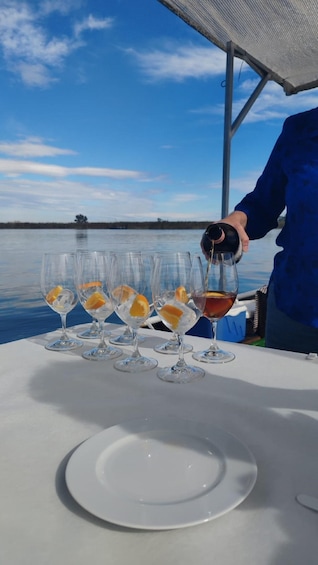 A person pouring a drink into a glass on a boat. 1