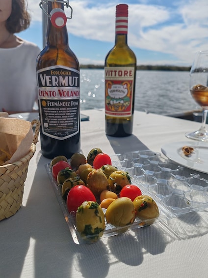 A table with a bottle of Vermut, a bottle of Vittore, and a plate of stuffed vegetables. 3