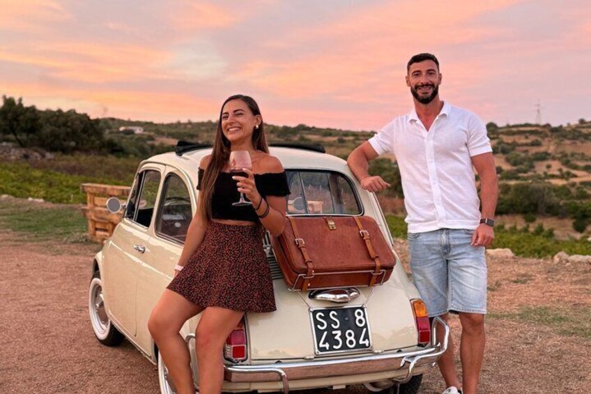 A vintage car with a license plate SS 8 4384 parked on a dirt road with a sunset in the background. 1