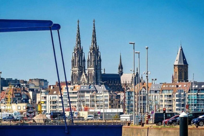 A cityscape with a prominent cathedral, modern buildings, and a bridge. 1