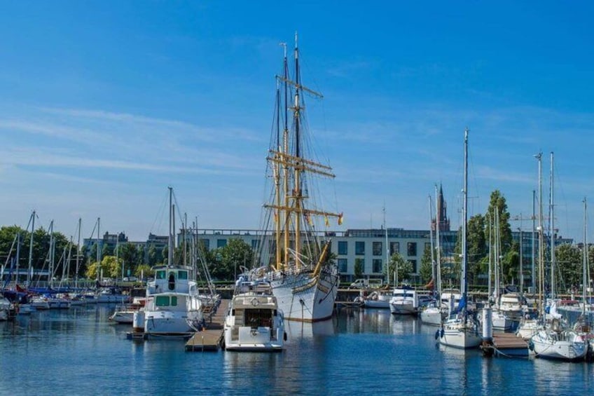 A marina with various boats, including a tall ship, and a building in the background. 4