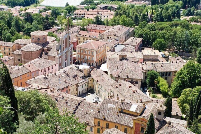 A densely packed urban area with historic buildings, a prominent church, and surrounding greenery. 1
