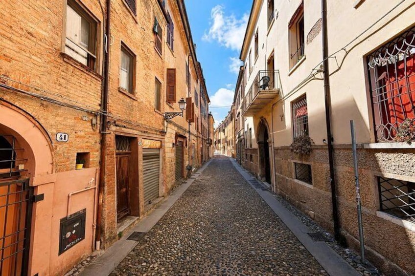 A cobblestone street lined with historic buildings, a clear blue sky, and a sign with the number 41. 2