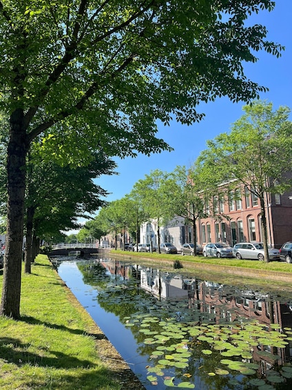 A canal lined with trees and buildings, reflecting the surroundings. 3