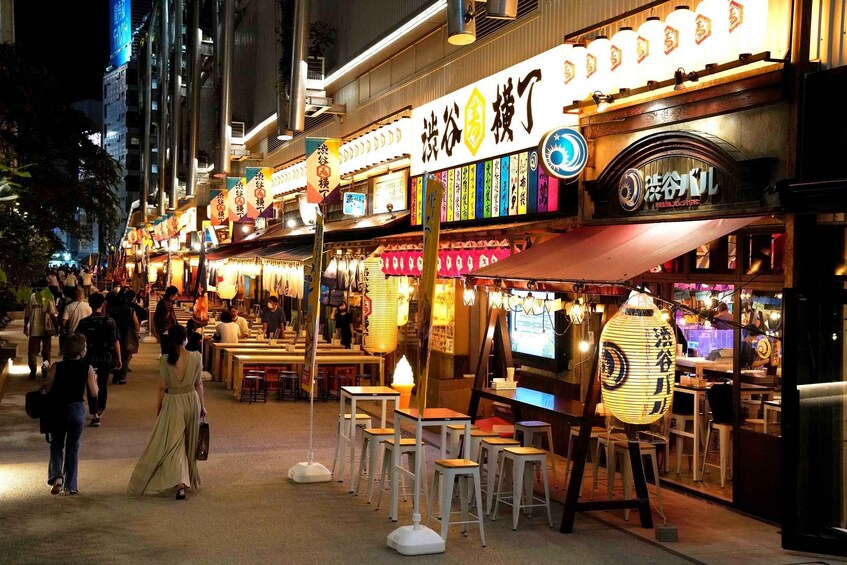 A bustling street at night with illuminated signs and storefronts. 4