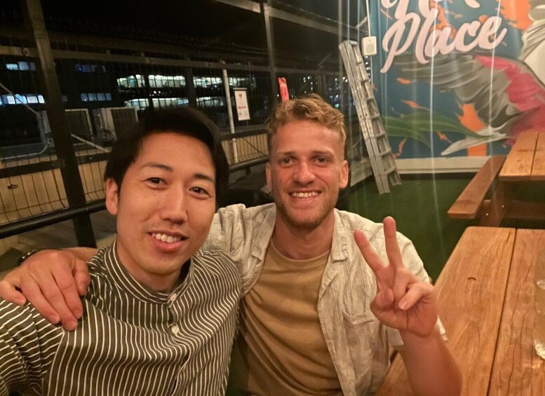 Two people sitting at a wooden table with a 'Place' sign in the background. 2
