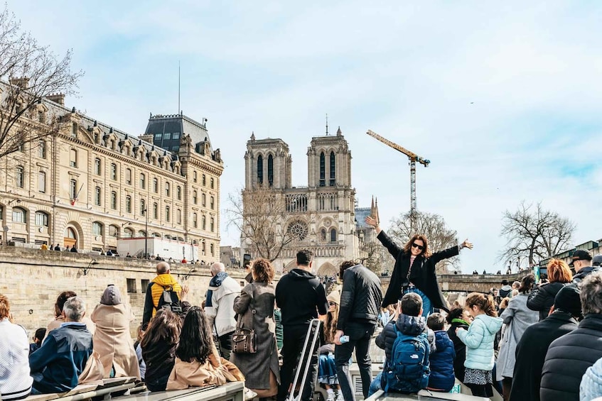 A crowd of people in front of Notre-Dame Cathedral with a construction crane in the background. 5