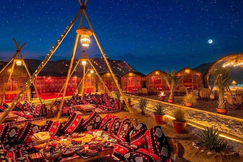 A night scene with yurts, string lights, and a desert landscape. 1