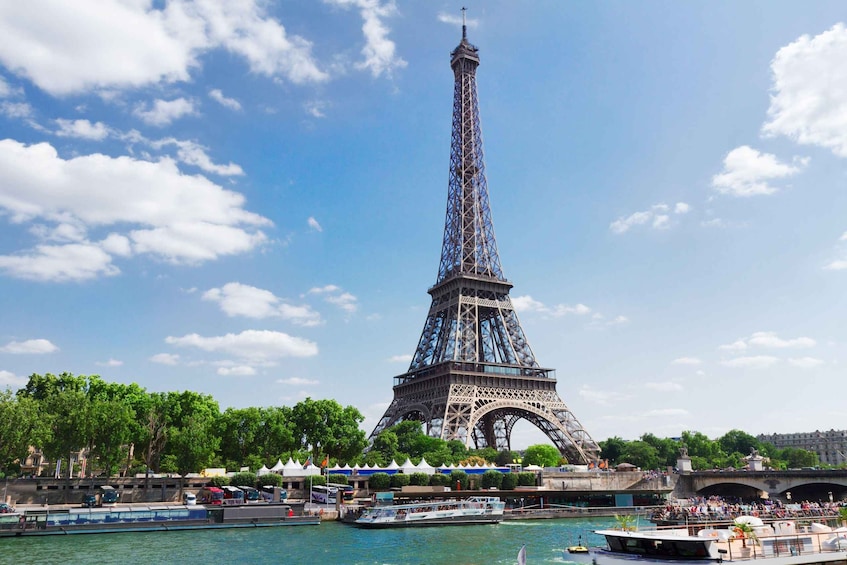 The Eiffel Tower with a river and boats in the foreground. 5