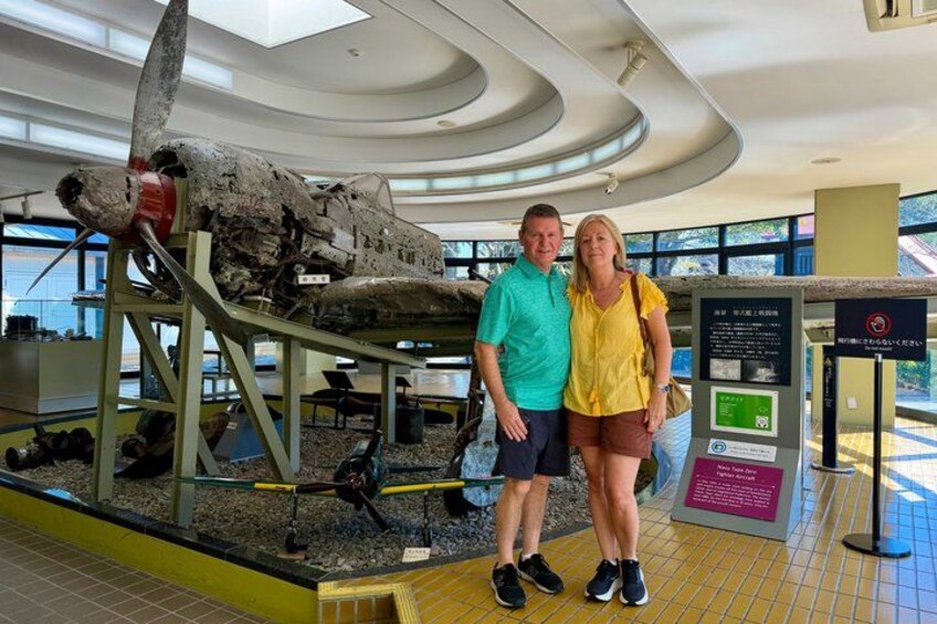 A large aircraft on display with a couple standing in front of it. 5