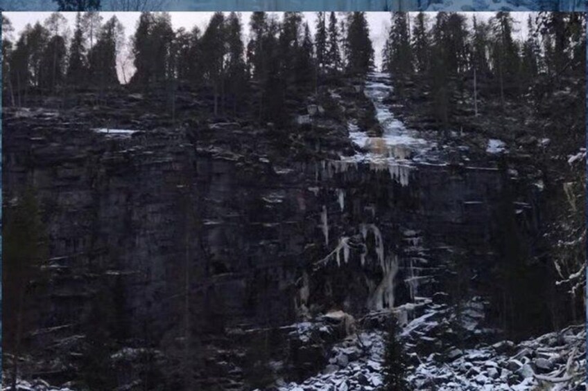 A snowy forest with a rocky cliff and a river. 5