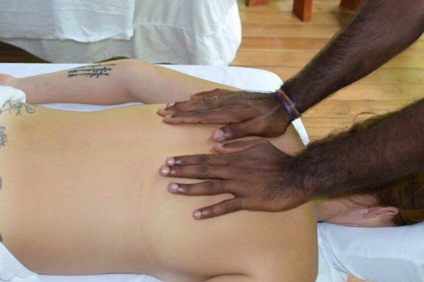 A person receiving a massage with hands on their back. 4