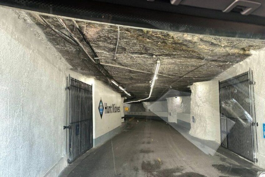 An underground parking garage with concrete walls, metal gates, and a visible Hunt Brothers logo. 3