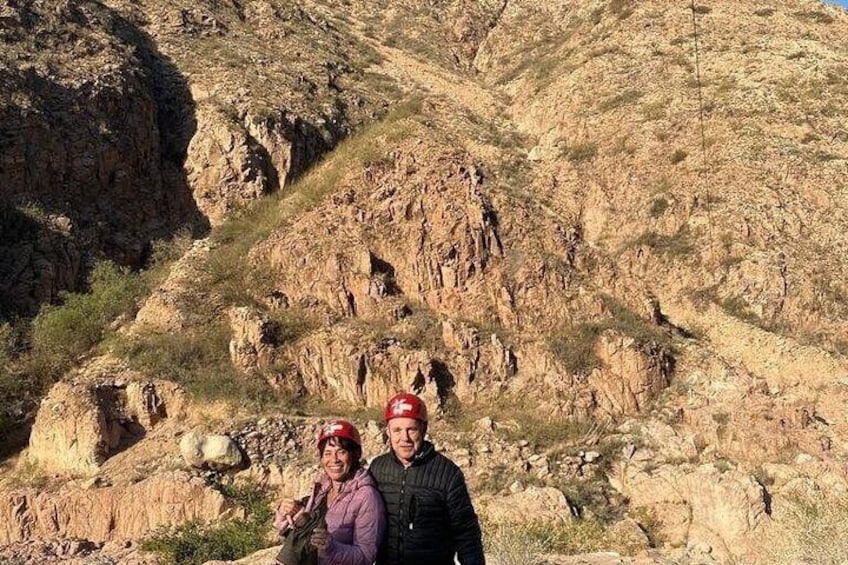 A rocky mountainous landscape with two people wearing red helmets. 2