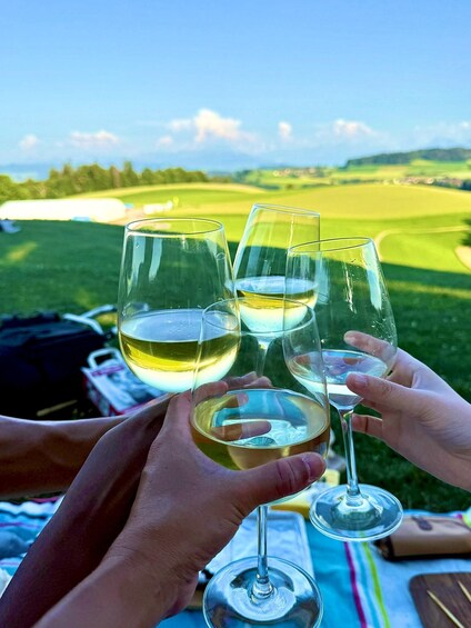 A person holding wine glasses with a golf course in the background. 1