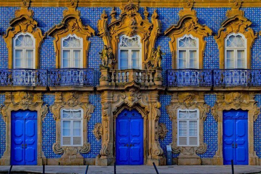 A building with blue doors and windows, ornate balconies, and a tiled facade. 5