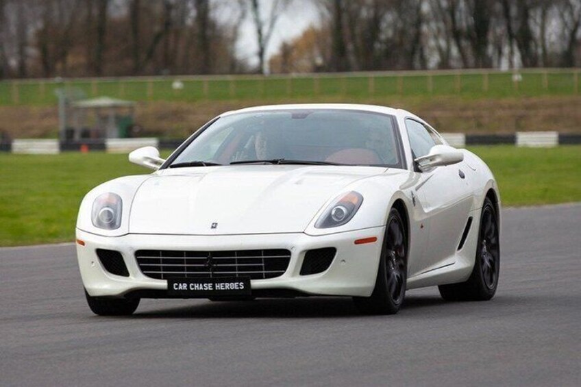 A white sports car on a racetrack. 1