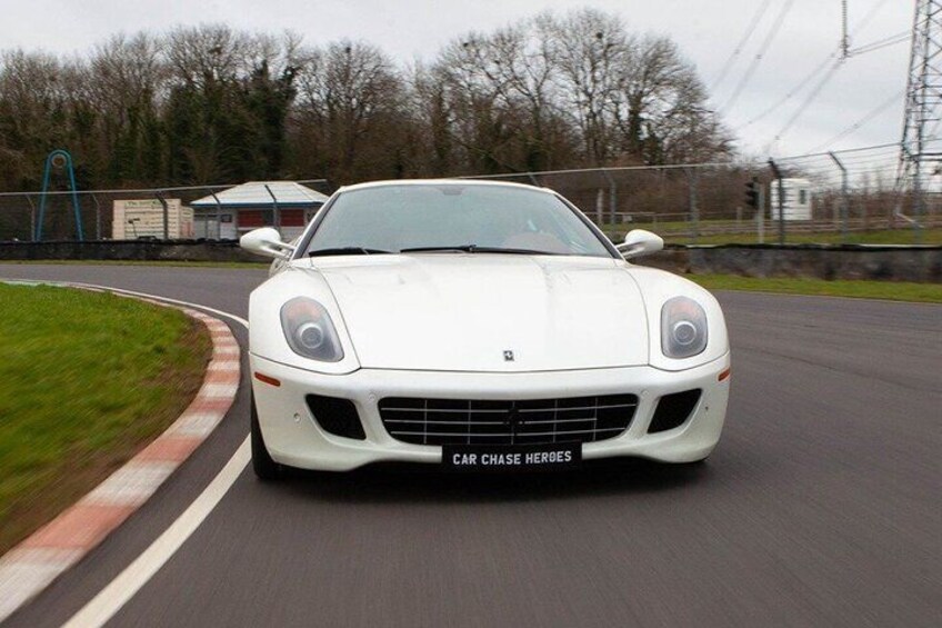 A white sports car on a racetrack. 5