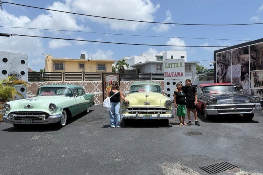 Vintage cars parked in a lot with a building labeled 'Little Havana' in the background. 2