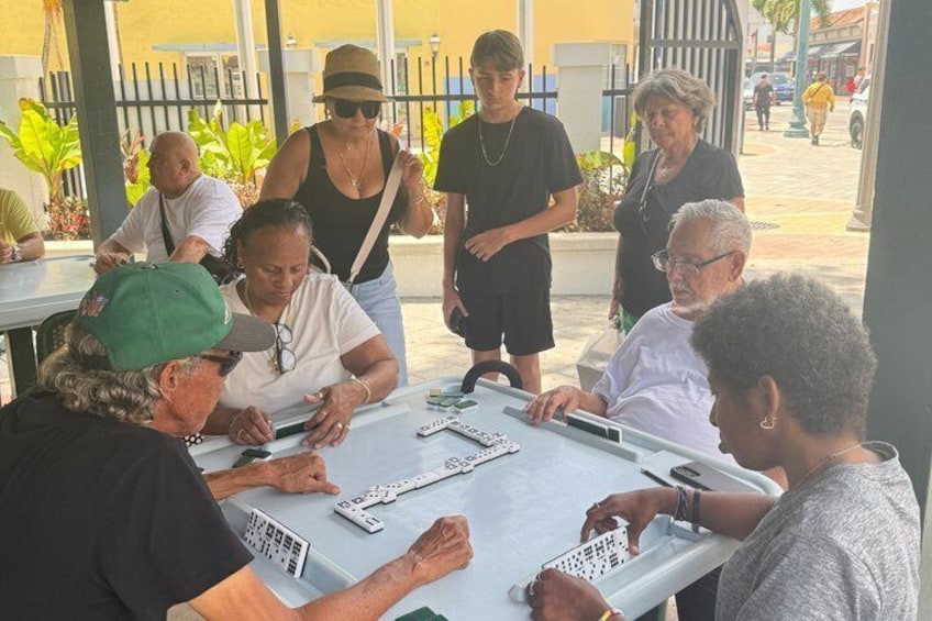 A group of people playing a board game at a table outdoors. 4