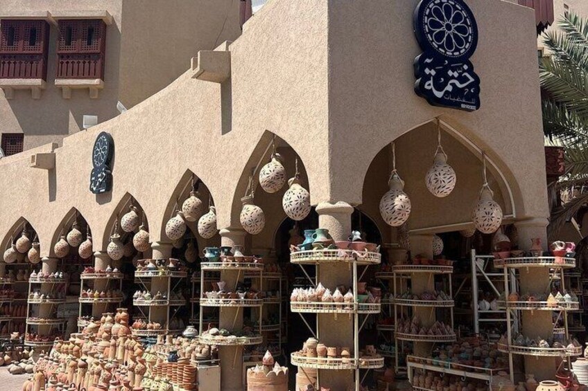 A traditional market with pottery and ceramics displayed under arches. 3