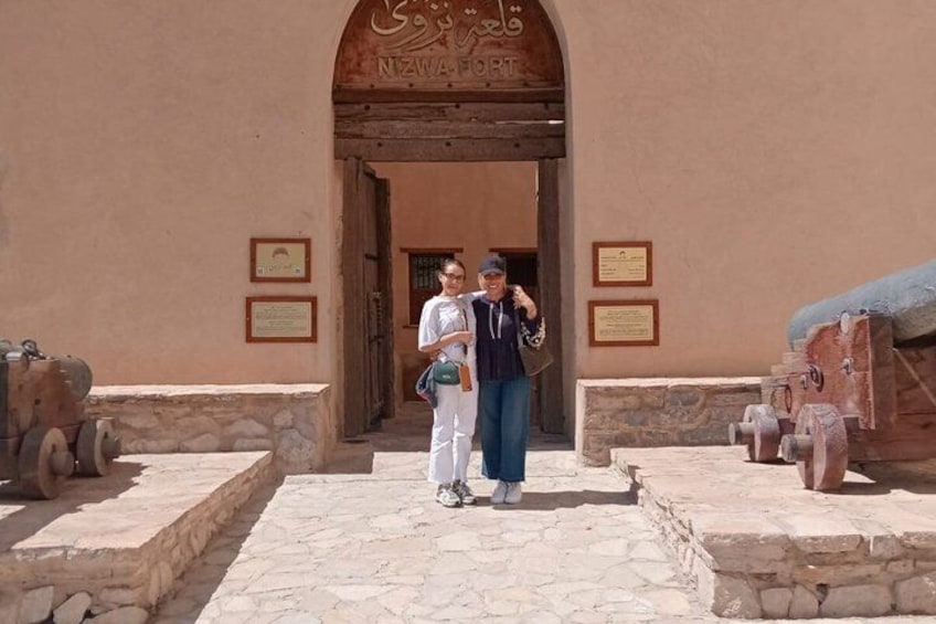 A building entrance with a sign reading 'NZWA PORT' and two individuals standing in front. 2