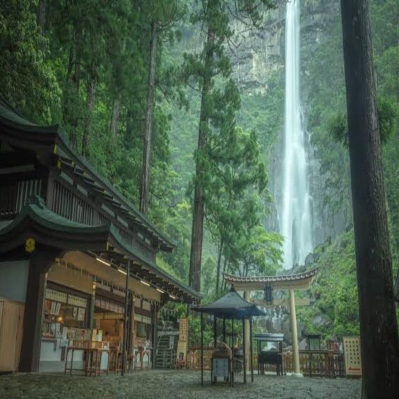 A traditional Japanese building with a waterfall in the background. 2