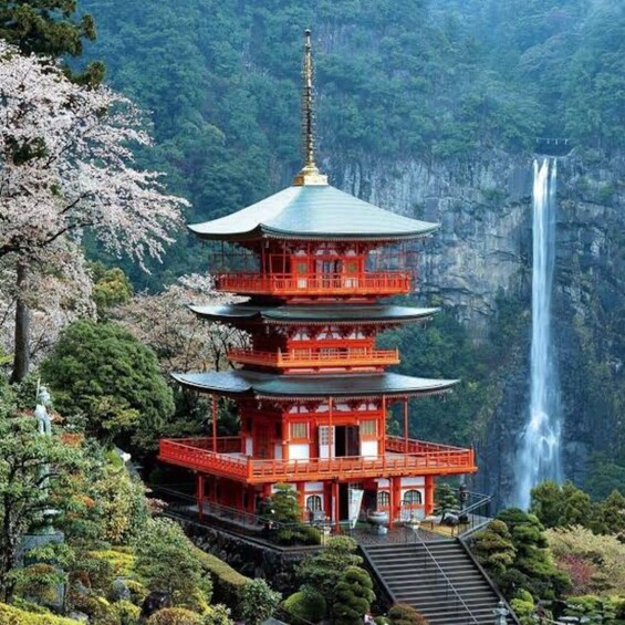 A multi-tiered pagoda with a waterfall in the background. 3