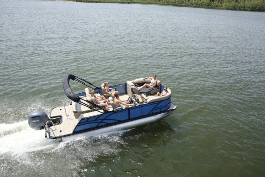 A blue and white motorboat with people on board, moving on a calm body of water. 1
