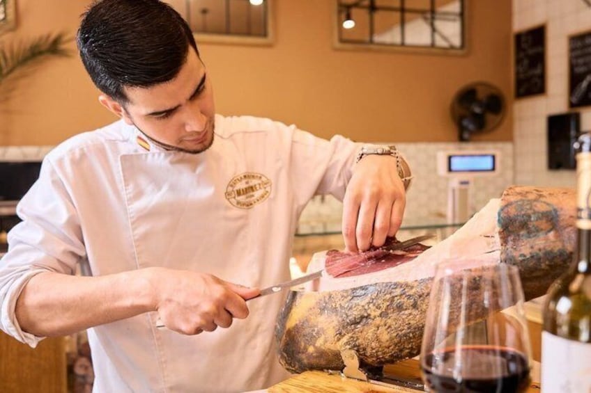 A chef slicing meat on a cutting board in a kitchen. 4