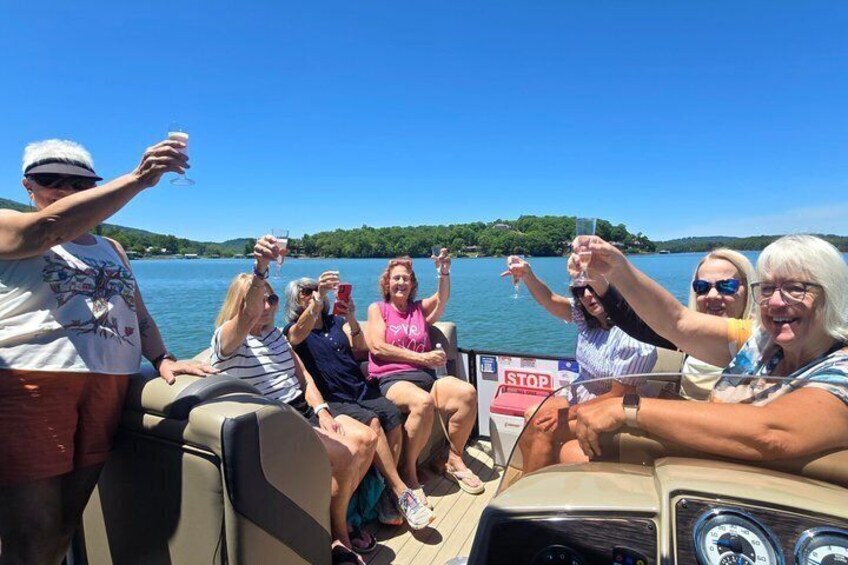 A group of people on a boat, some holding drinks, with a 'STOP' sign visible. 4