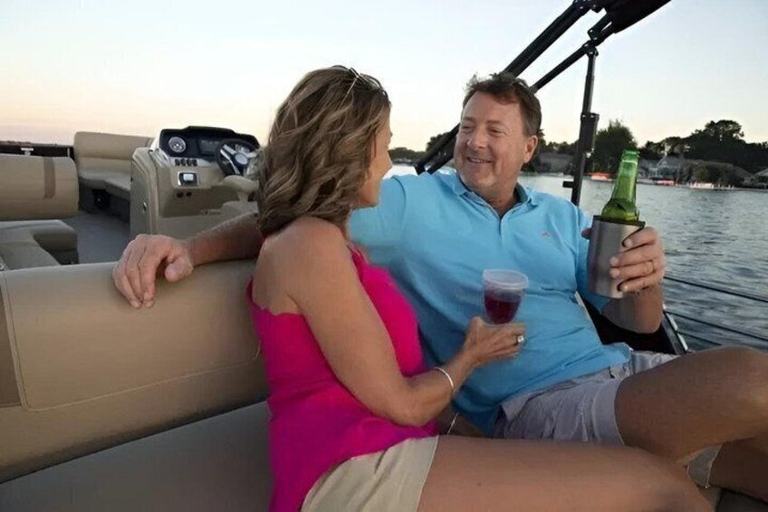 A couple on a boat with a bottle of champagne and a glass of red wine. 1